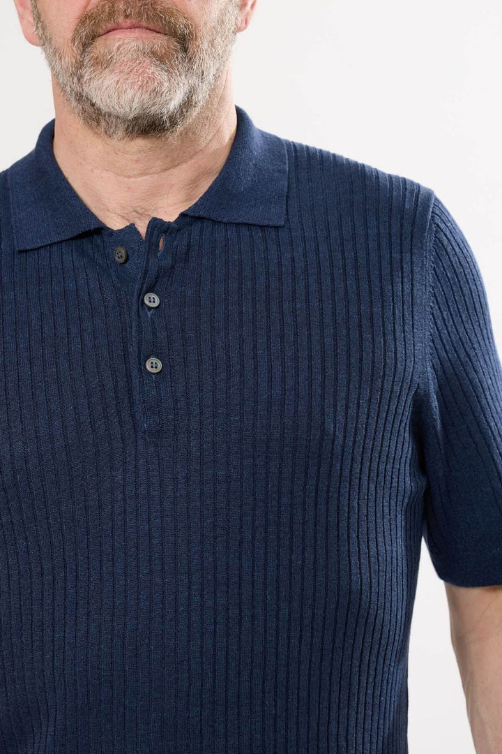 Polo en lin et coton bleu marine avec col classique et trois boutons pour ajustement.
