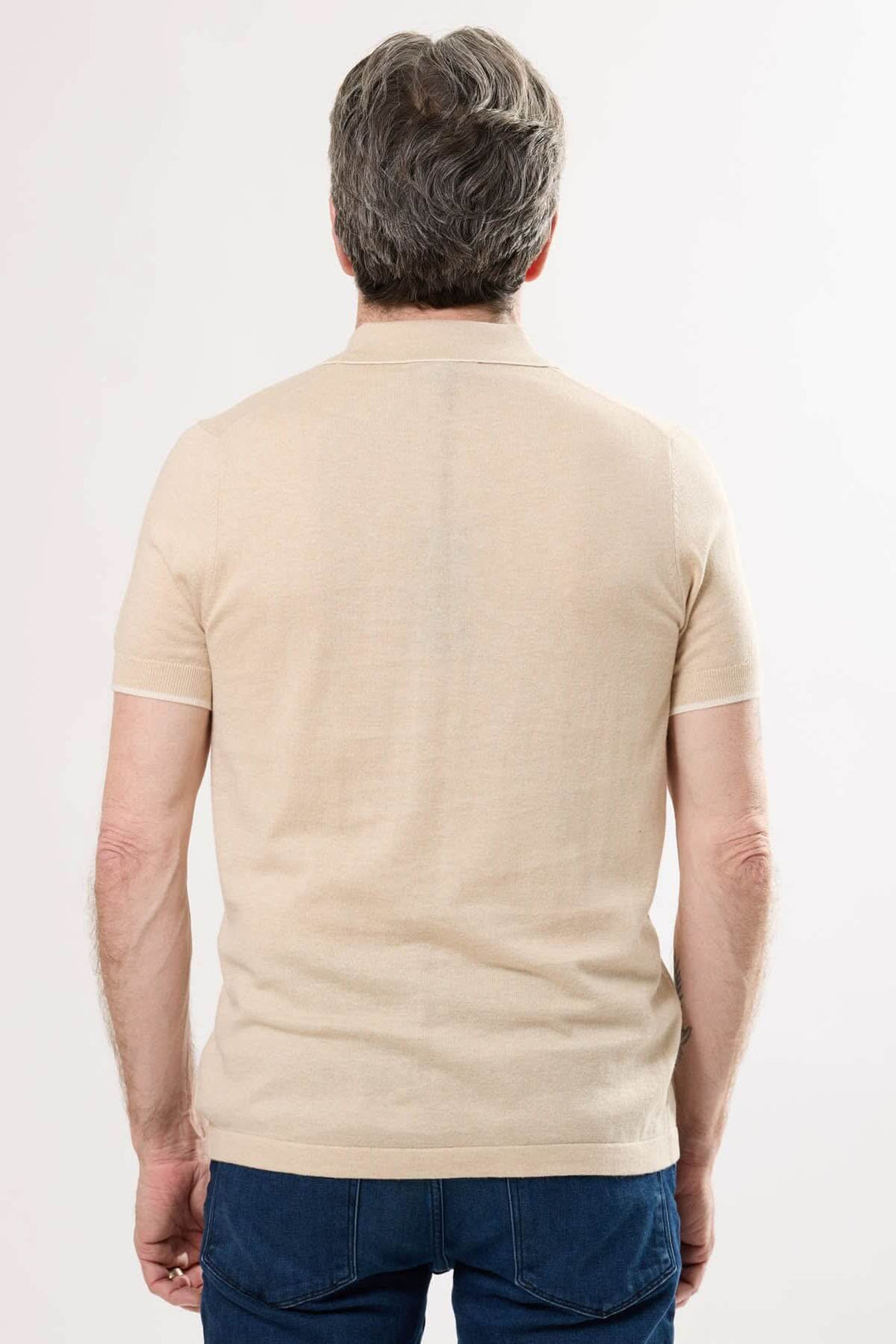Polo en tricot fin beige, vue arrière, idéal pour un style décontracté et élégant en été.