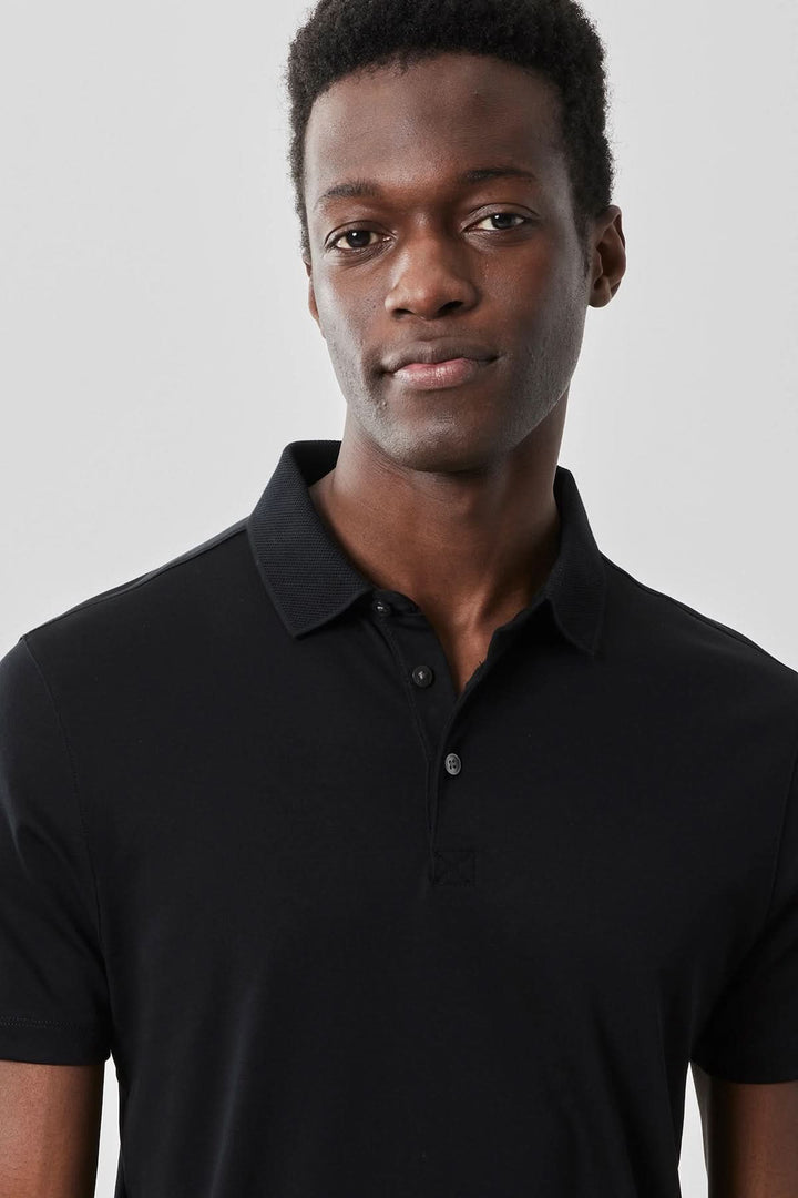 Polo manches courtes Georgia en noir, col de chemise élégant, style décontracté et sophistiqué.