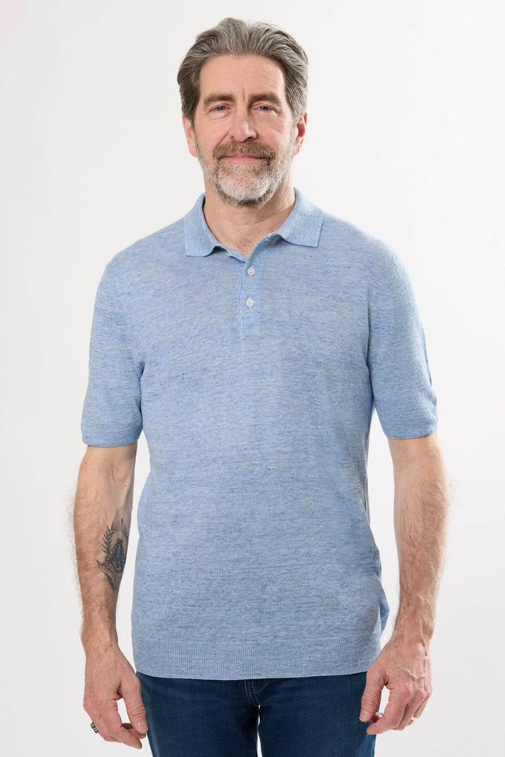 Homme portant un polo raffiné bleu, col structuré et manches courtes, idéal pour un look décontracté chic.