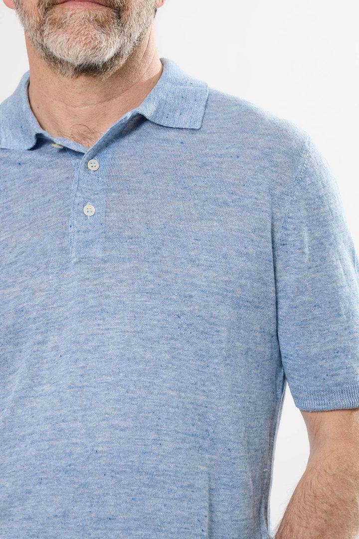 Polo raffiné en maille texturée bleue, col structuré et manches courtes, idéal pour un look décontracté chic.