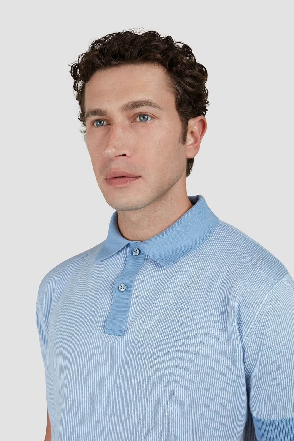 Polo léger en maille à rayures fines, élégant et décontracté, porté par un homme avec col contrastant.