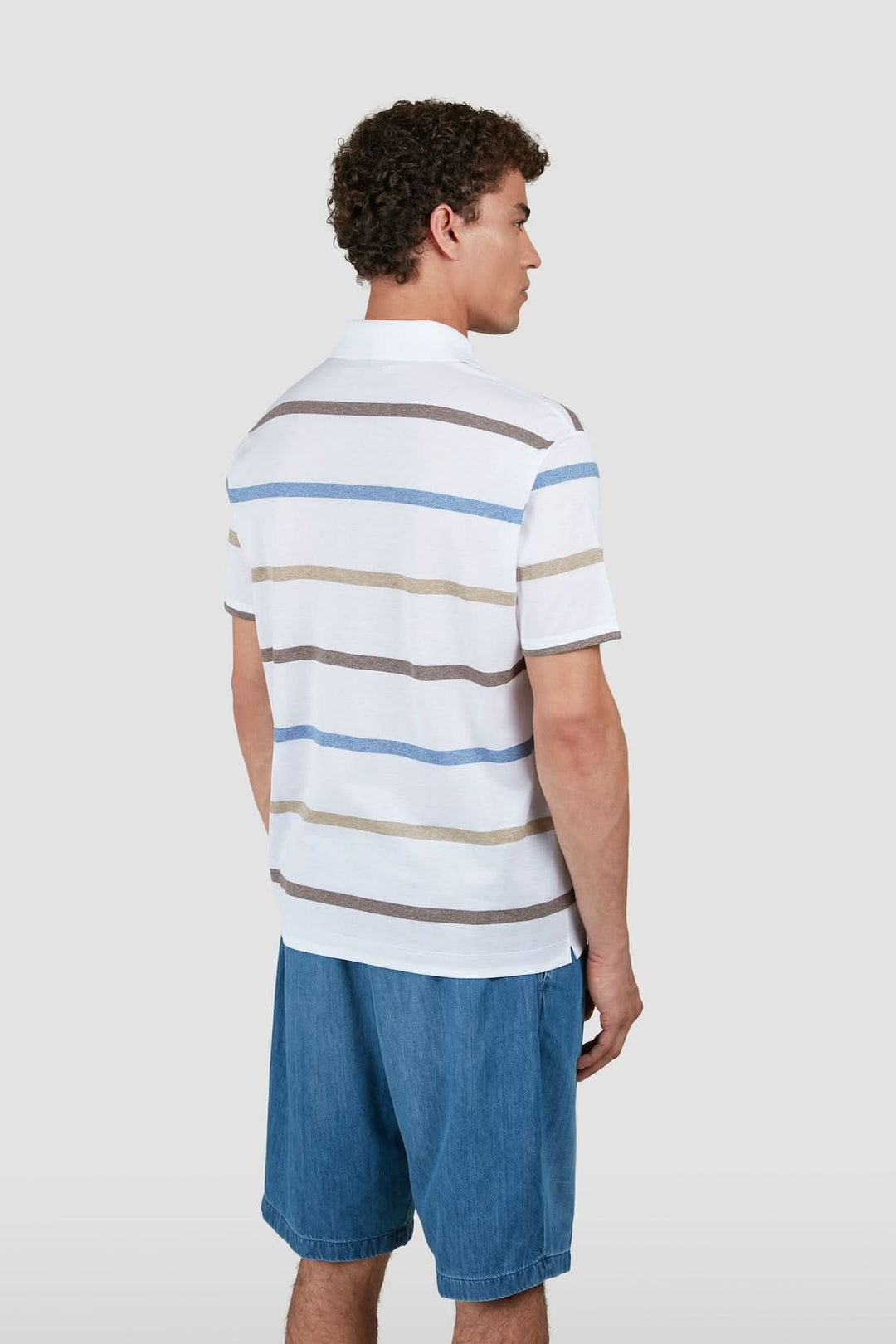 Homme portant un Polo rayé en coton piqué avec coupe régulière, vu de dos. Motif à rayures horizontales, style estival élégant.