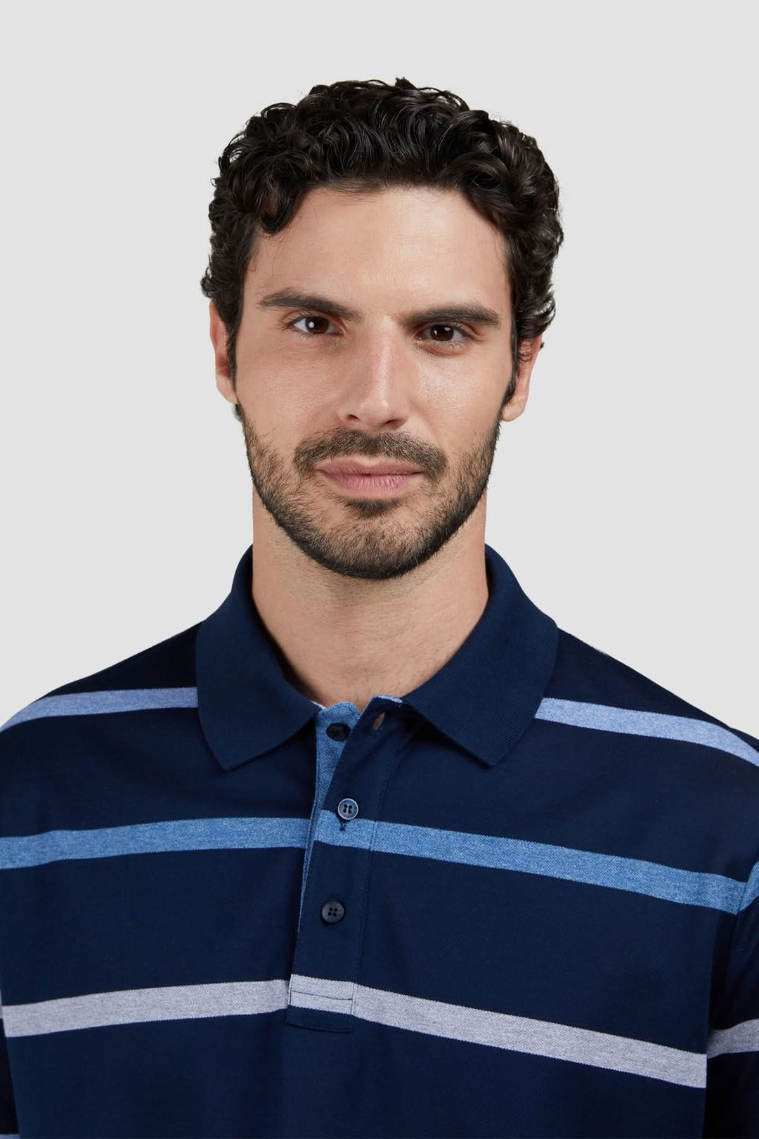 Homme portant un polo rayé en coton piqué avec coupe régulière et motif à rayures horizontales bleues et blanches.