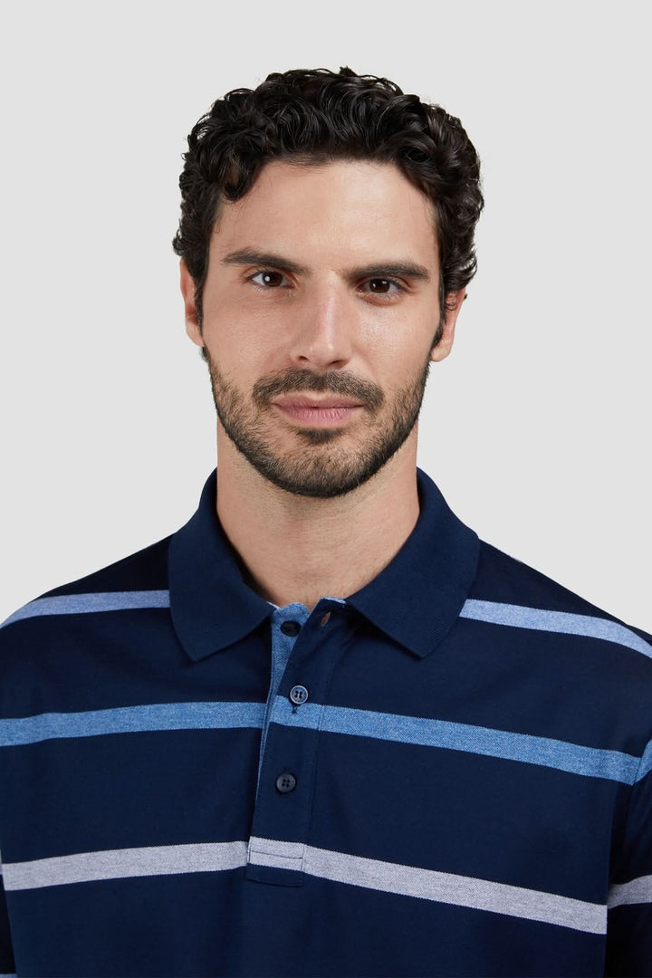 Homme portant un polo rayé en coton piqué avec coupe régulière et motif à rayures horizontales bleues et blanches.