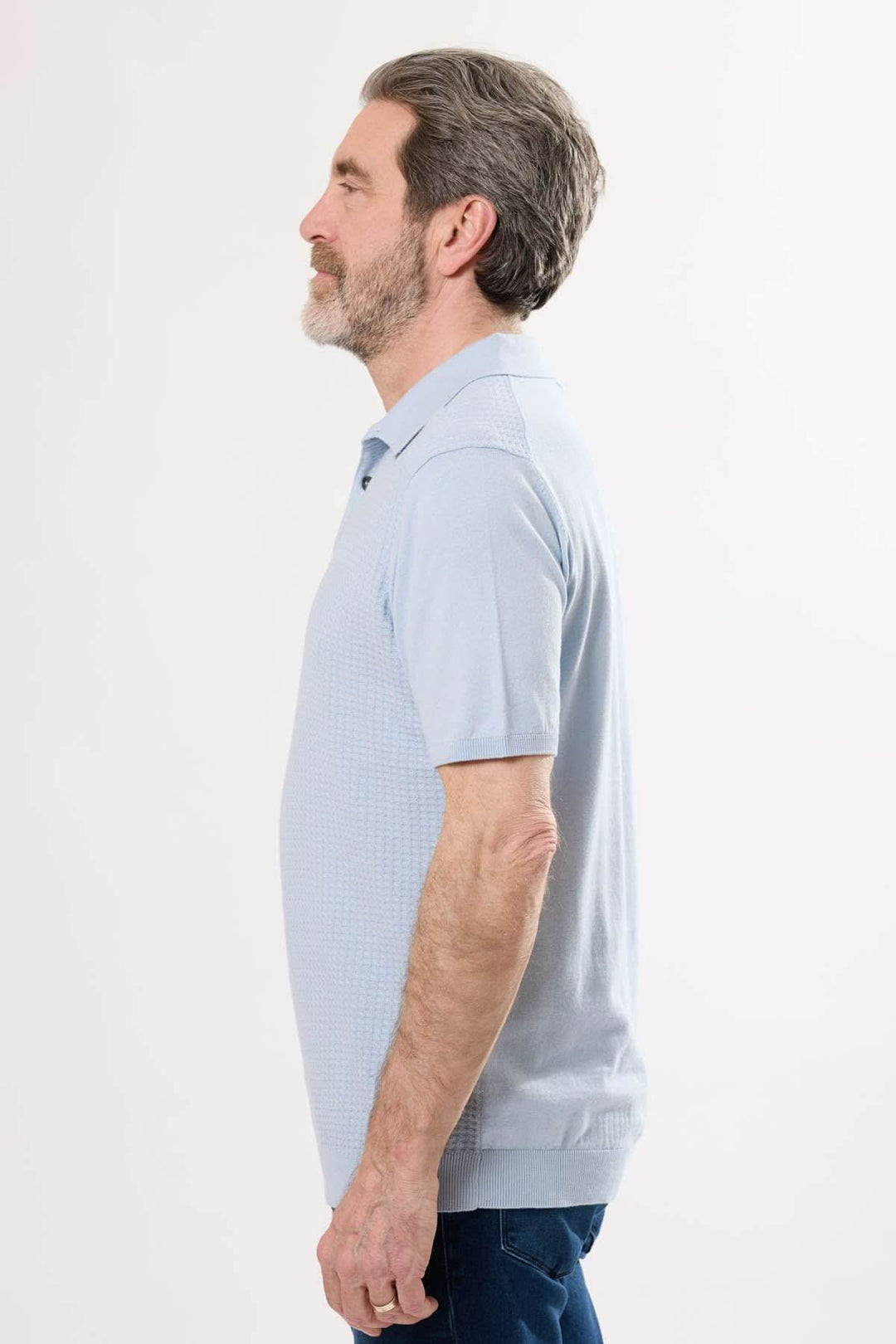 Homme portant un polo rétro bleu, élégant et confortable, avec col classique et manches courtes.