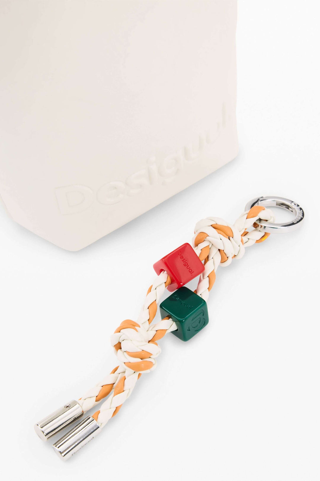 Breloque colorée attachée au porte-feuille compact à bandoulière, design épuré et minimaliste.