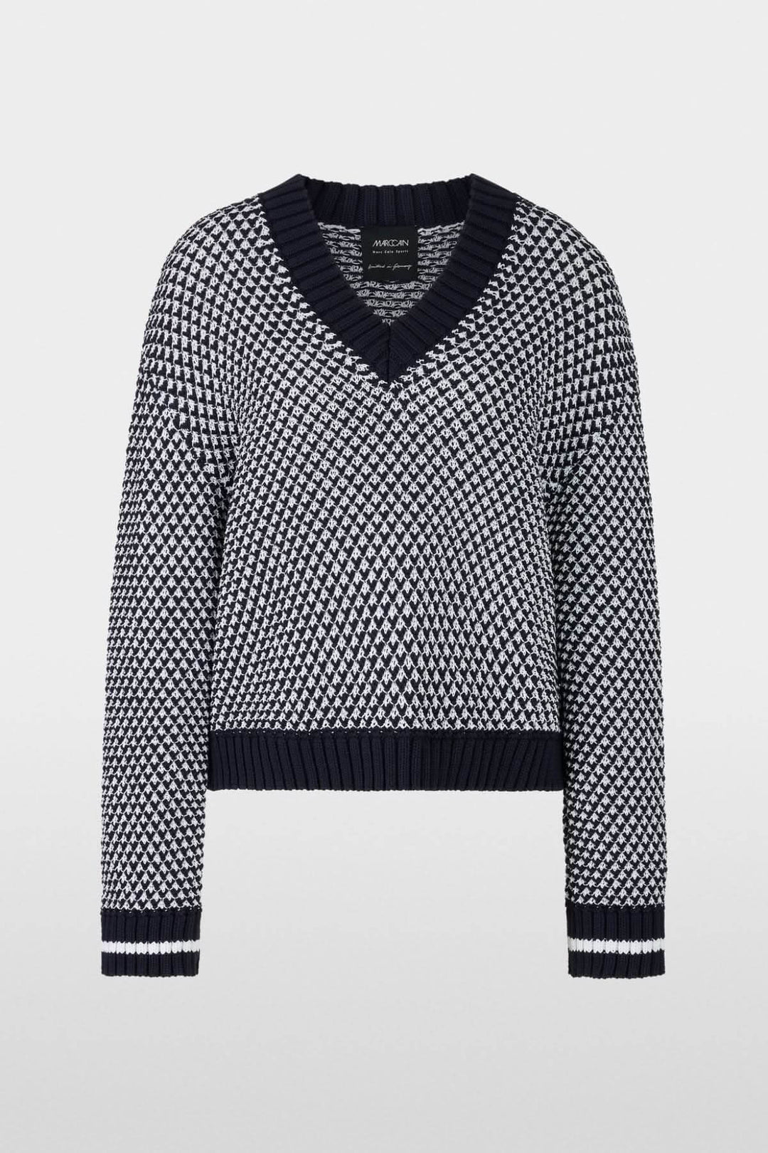 Pull court tricoté noir et blanc avec encolure en V, au design graphique et confortable.