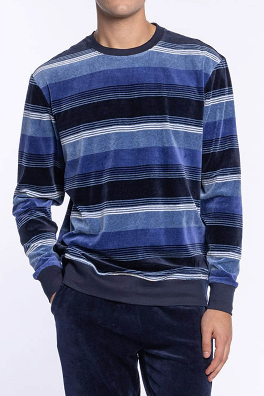 Homme portant un Pyjama Long en Velours de Coton à Rayures, manches longues, col rond, tons de bleu, pour soirées détente et nuits d'hiver.
