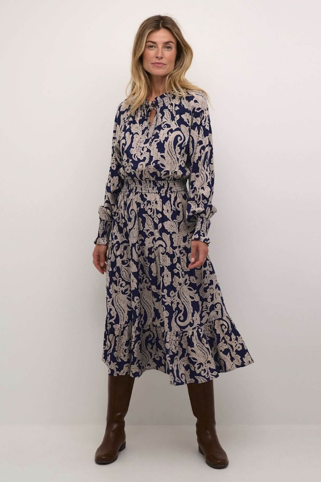 Robe Lucy longue à motif beige sur fond bleu marine, manches longues, encolure goutte, cintrée à la taille.