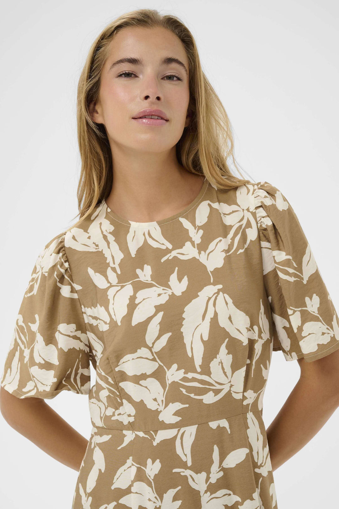 Robe Marlo midi fluide à imprimé végétal, avec encolure ronde et manches courtes fluides, mettant en valeur la silhouette.