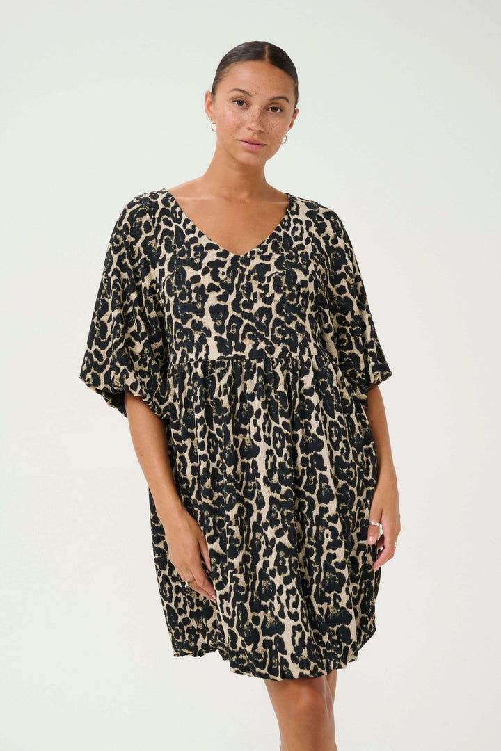 Robe Nani à imprimé léopard, courte avec encolure en V et manches amples, offrant un style moderne et audacieux.