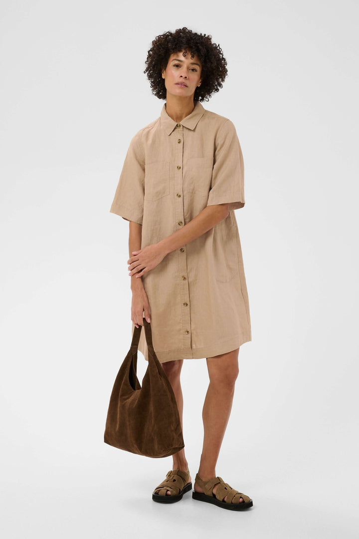Femme portant une robe chemise en lin Sardiae avec une silhouette droite et épurée, style décontracté et soigné idéal pour un look minimaliste.