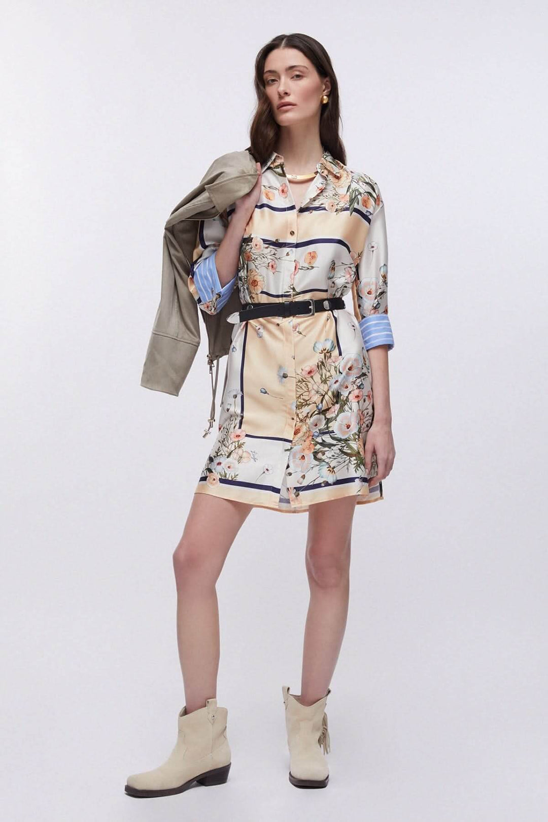 Femme portant une robe chemise à imprimé floral avec manches trois-quarts et col classique, assortie de bottines crème et une veste beige.