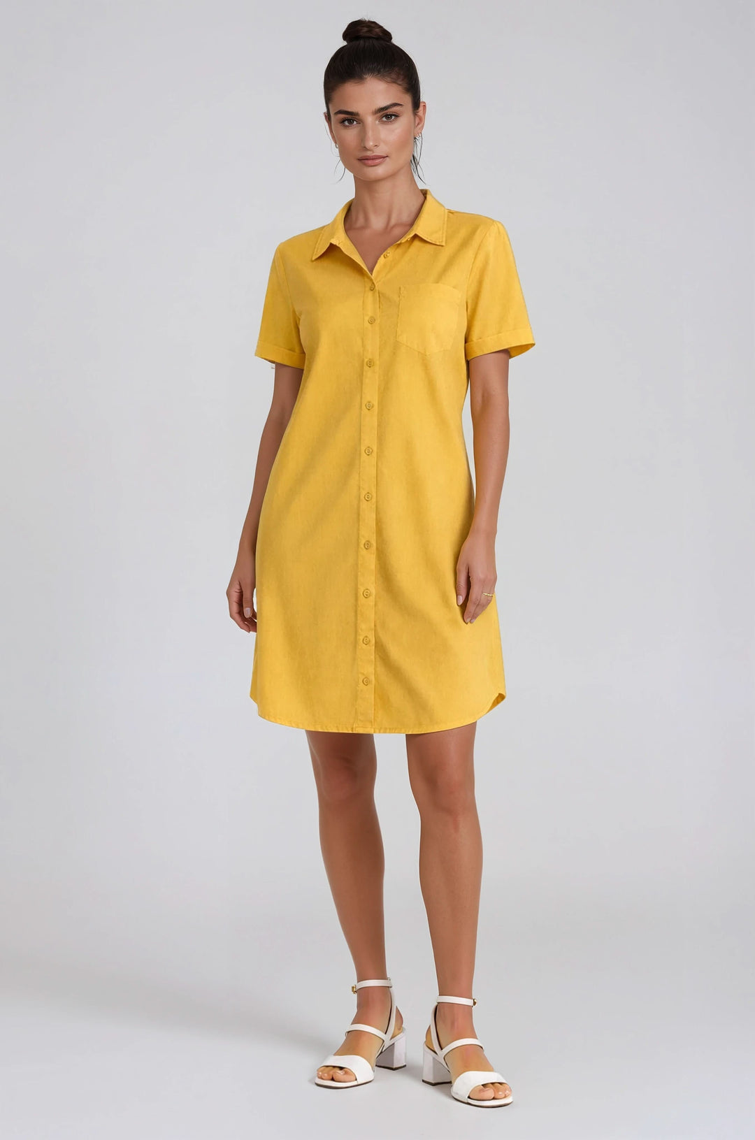 Femme portant une robe chemise à manches courtes boutonnée jaune, coupe droite et confortable pour un style structuré et décontracté.