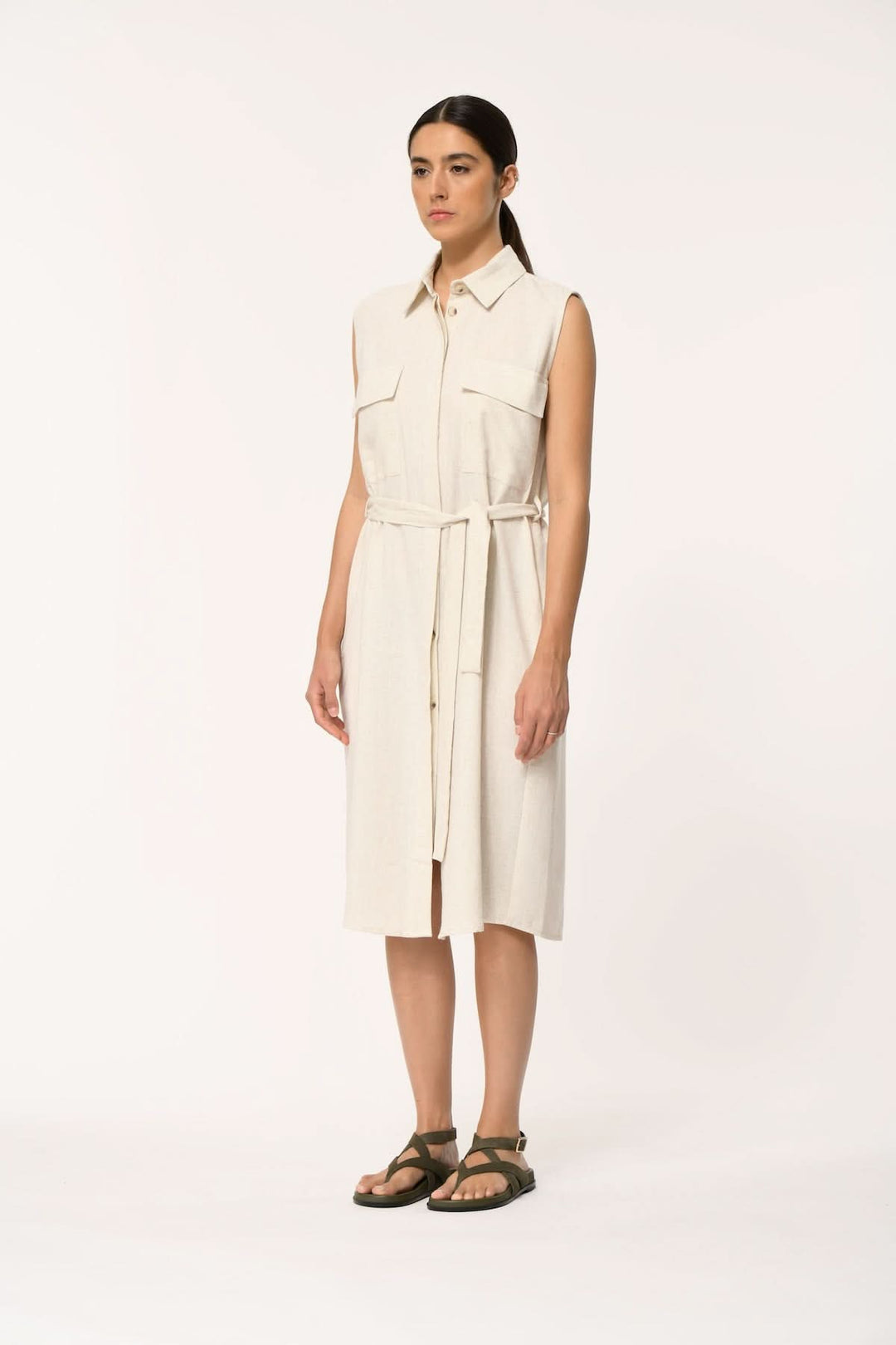 Femme portant une robe chemise sans manches ceinturée LALORA avec ceinture à nouer, élégante et moderne, longueur midi, col classique.