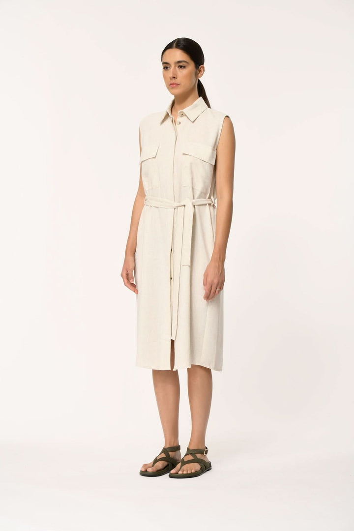 Femme portant une robe chemise sans manches ceinturée LALORA avec ceinture à nouer, élégante et moderne, longueur midi, col classique.