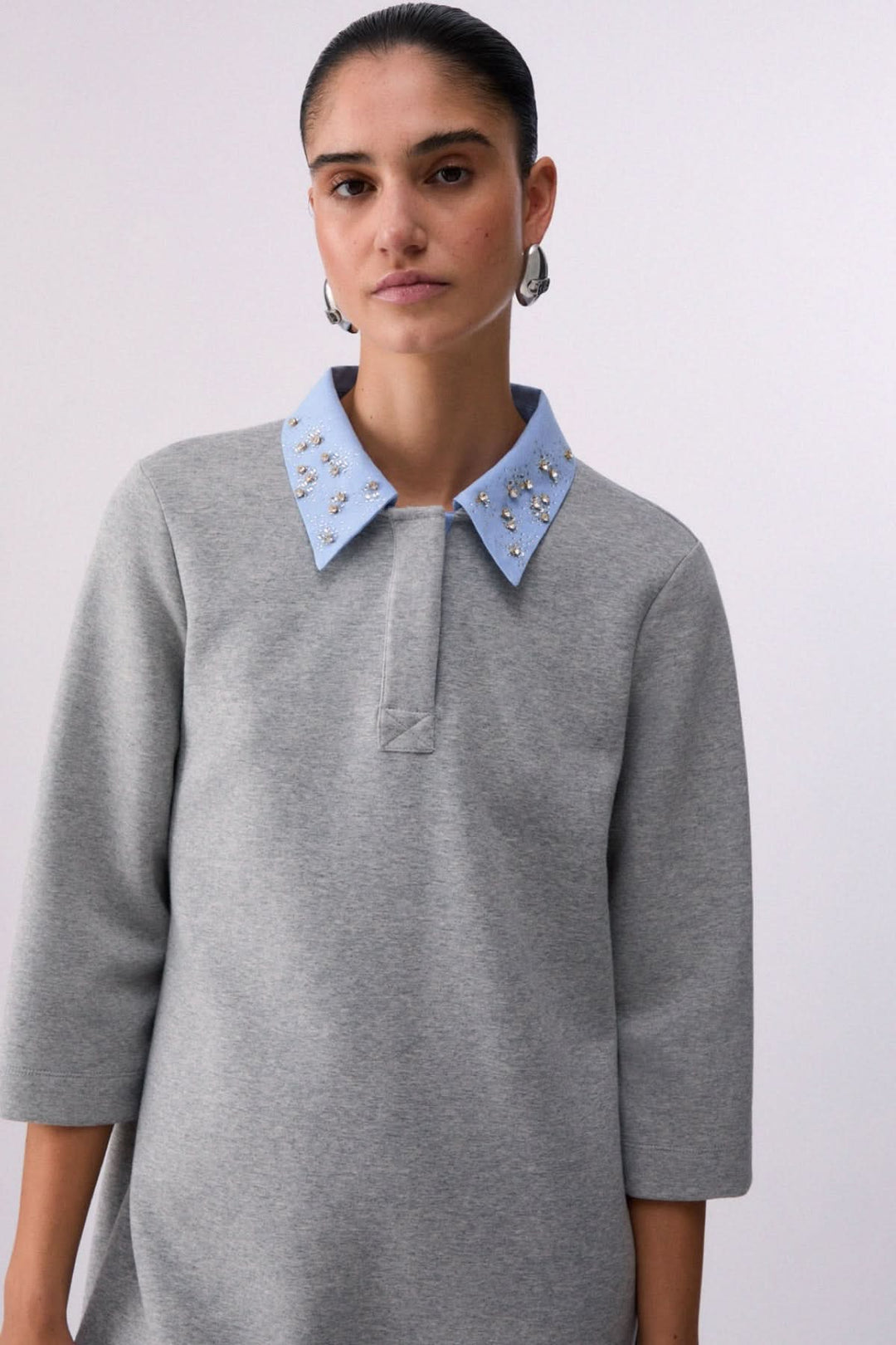 Robe courte à col polo orné avec manches trois-quarts et détails décoratifs sur le col. Style sport-chic et silhouette minimaliste.