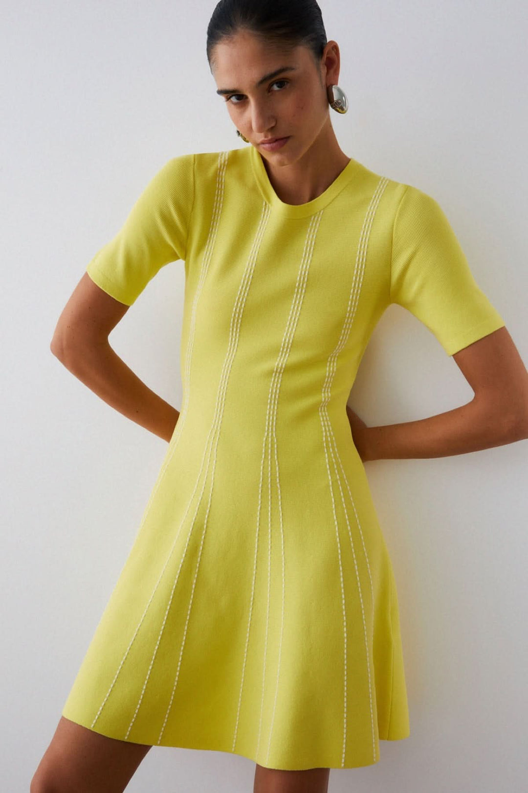 Robe courte en maille à motif rayé jaune avec encolure ronde et manches courtes, idéale pour un look élégant et polyvalent.