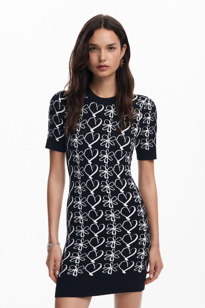 Robe courte en maille imprimée avec motifs de cœurs et fleurs, style romantique et ajusté.