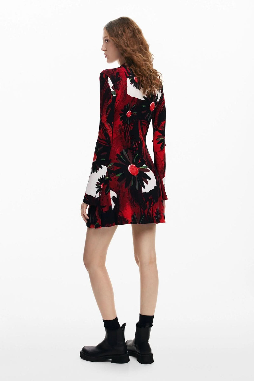 Robe courte à manches longues avec imprimé floral rouge et noir, stylée avec des bottines noires.