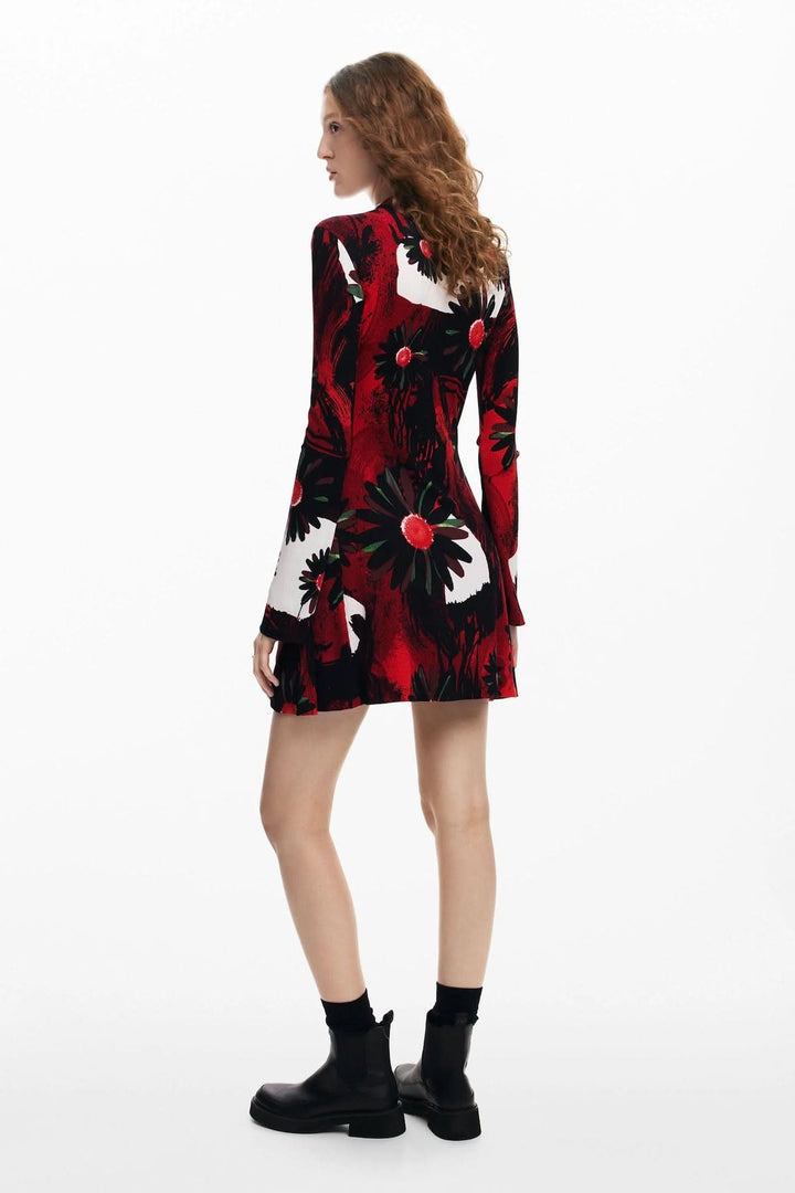 Robe courte à manches longues avec imprimé floral rouge et noir, stylée avec des bottines noires.