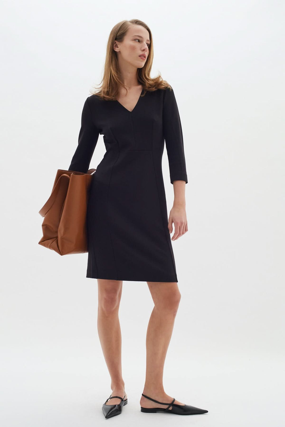 Femme portant une Robe droite encolure en V Pannie manches longues élégante pour un style professionnel et quotidien.