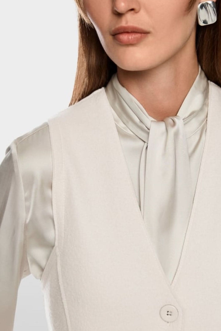 Femme portant une Robe en laine bouillie sans manches, imprimé urbain artistique et patte de boutonnage, tricotée en Allemagne.