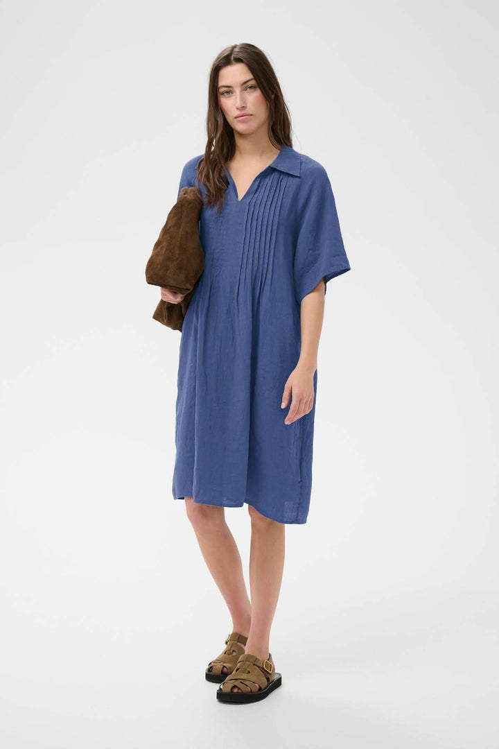Robe en lin Ayla bleue à coupe droite avec détails plissés, portée par un modèle, idéale pour un style épuré et décontracté.