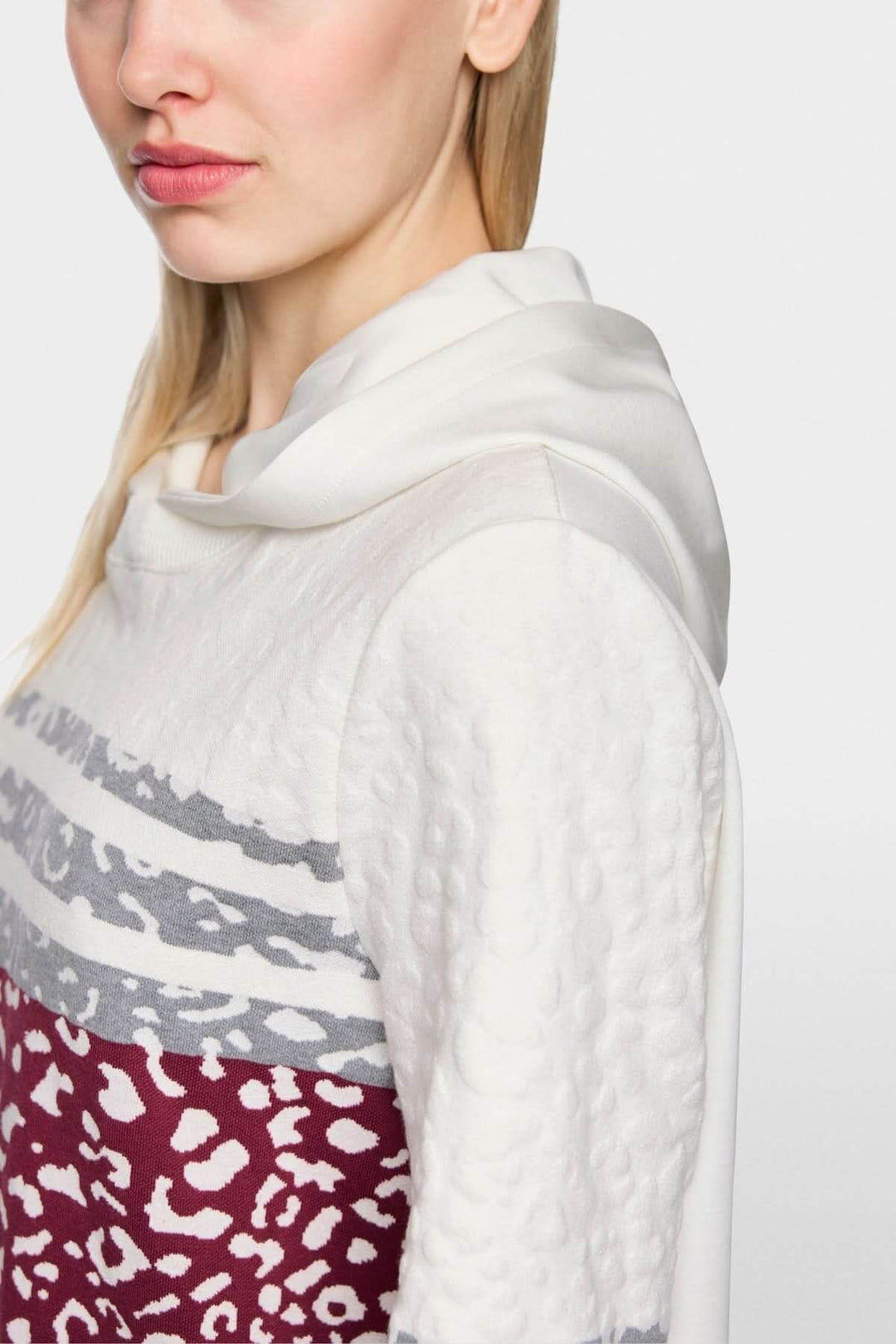 Robe en maille léopard à capuche avec détails tricotés et jersey doux, vue de côté, montrant le motif léopard et la capuche confortable.