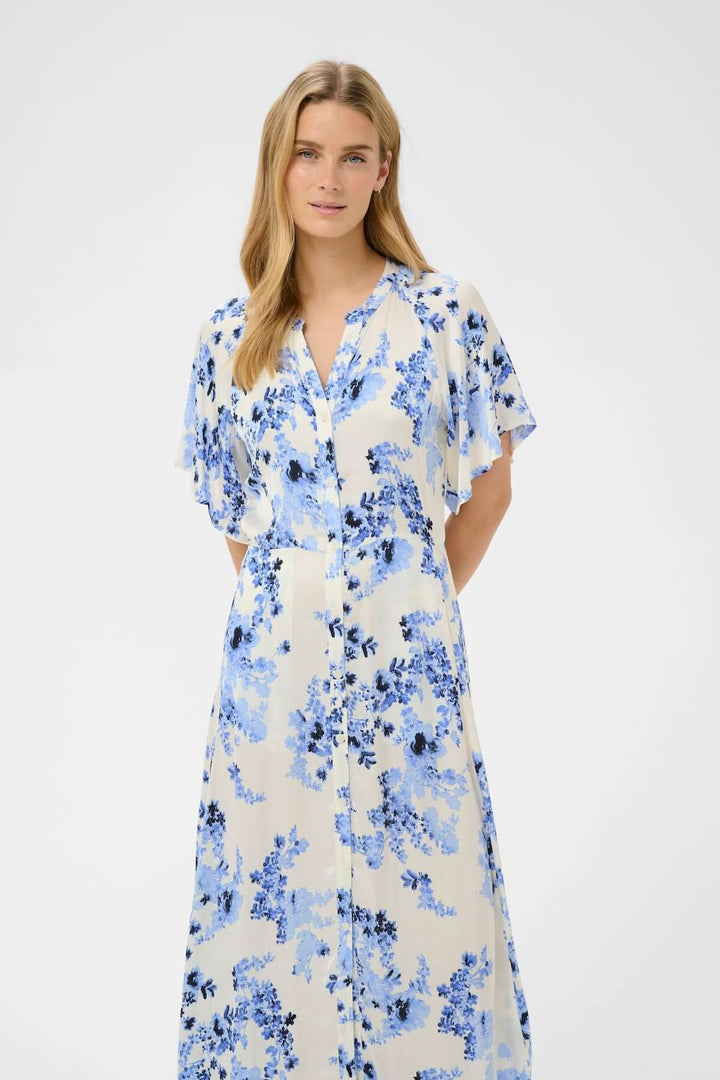 Robe fleurie Alaja sur modèle, robe midi fluide à imprimé floral bleu, élégante et féminine, boutonnage classique, coupe droite.