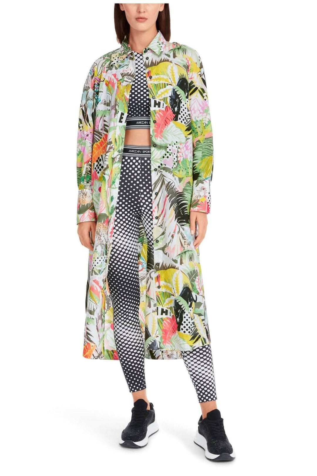 Robe imprimée jungle longue avec motifs colorés, portée sur un ensemble de leggings à pois et sneakers.