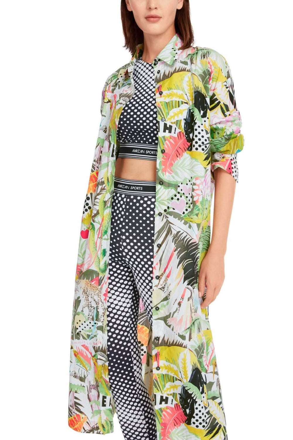 Robe imprimée jungle avec motifs de flore, portée sur des leggings à pois, style décontracté et tendance.