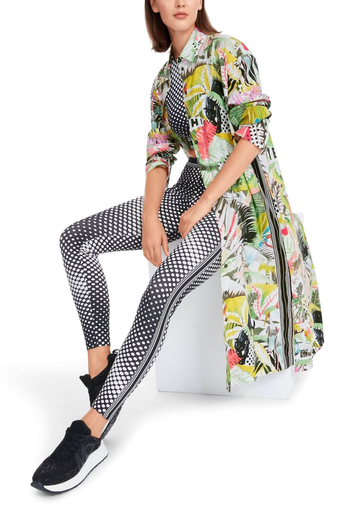 Robe imprimée jungle à motifs floraux portée avec leggings à pois, style décontracté et moderne.