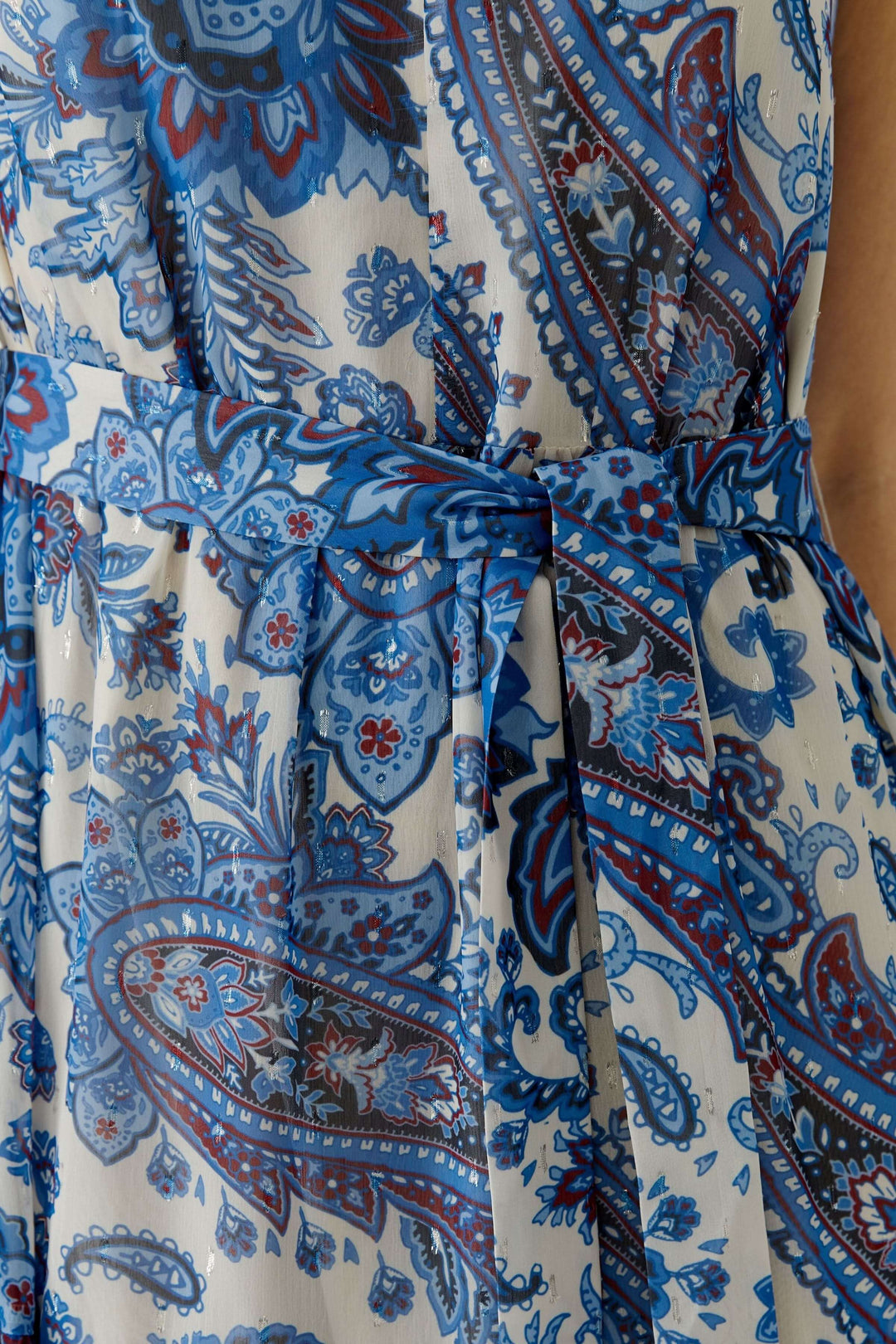 Robe longue à imprimé paisley avec ceinture à nouer, motif bleu et rouge, encolure en V, tissu fluide, détails élégants.