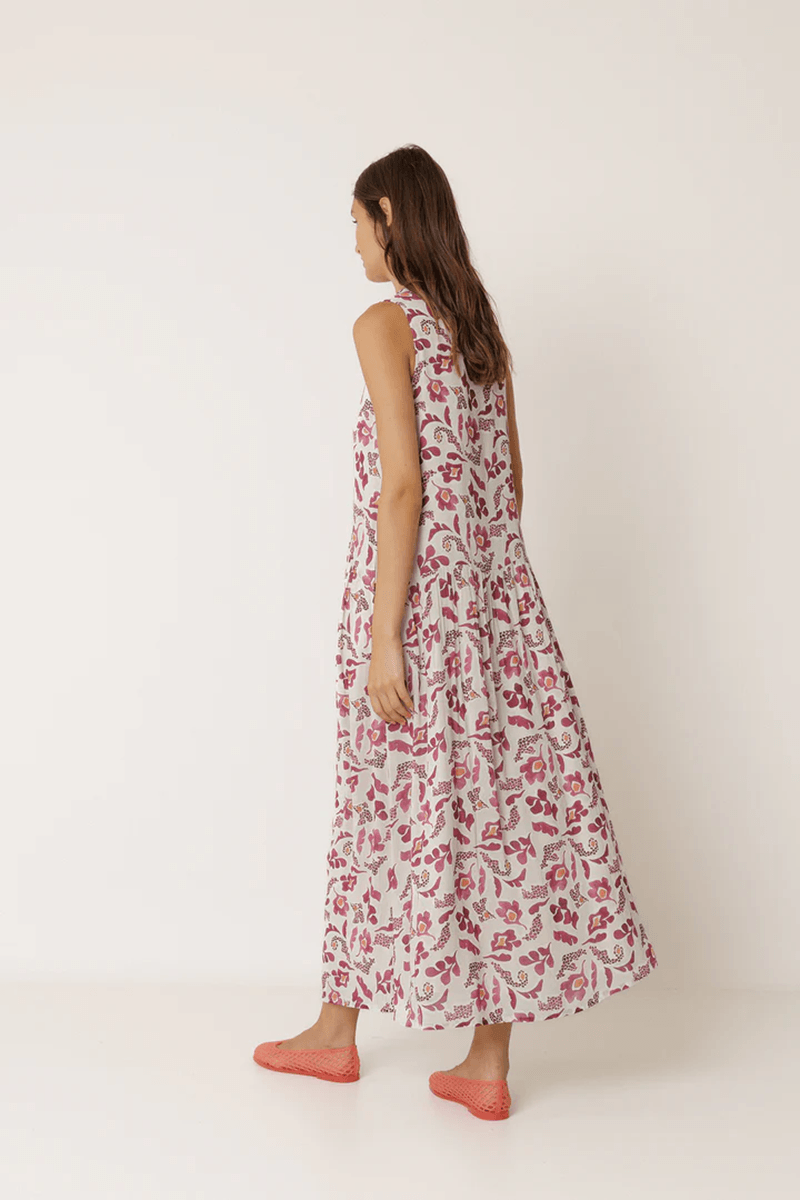 Robe longue imprimée sans manches avec imprimé délicat et silhouette fluide, portée par une femme.