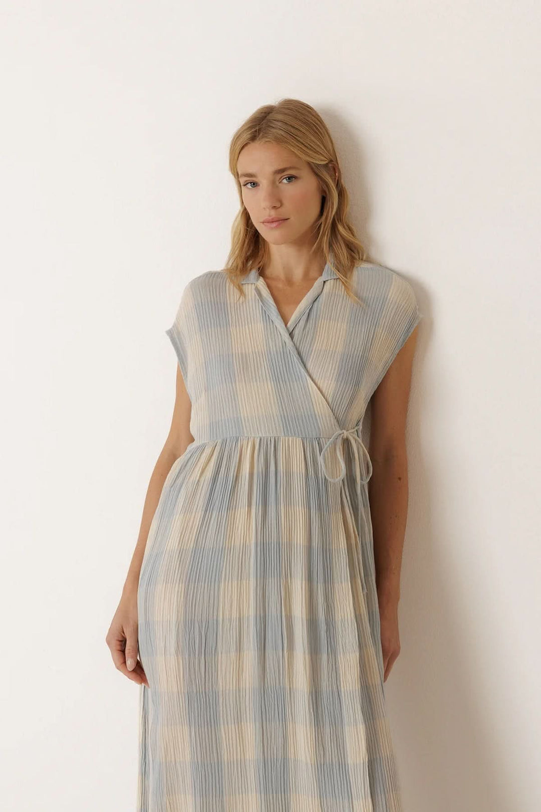 Robe longue portefeuille à carreaux, élégante et confortable, avec une coupe portefeuille et texture légère, portée par une femme.