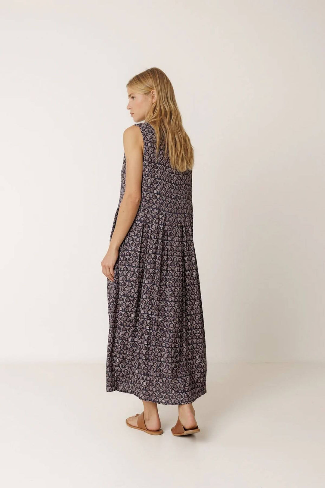 Femme portant une robe longue réversible à imprimé, coupe fluide, idéale pour l'été.