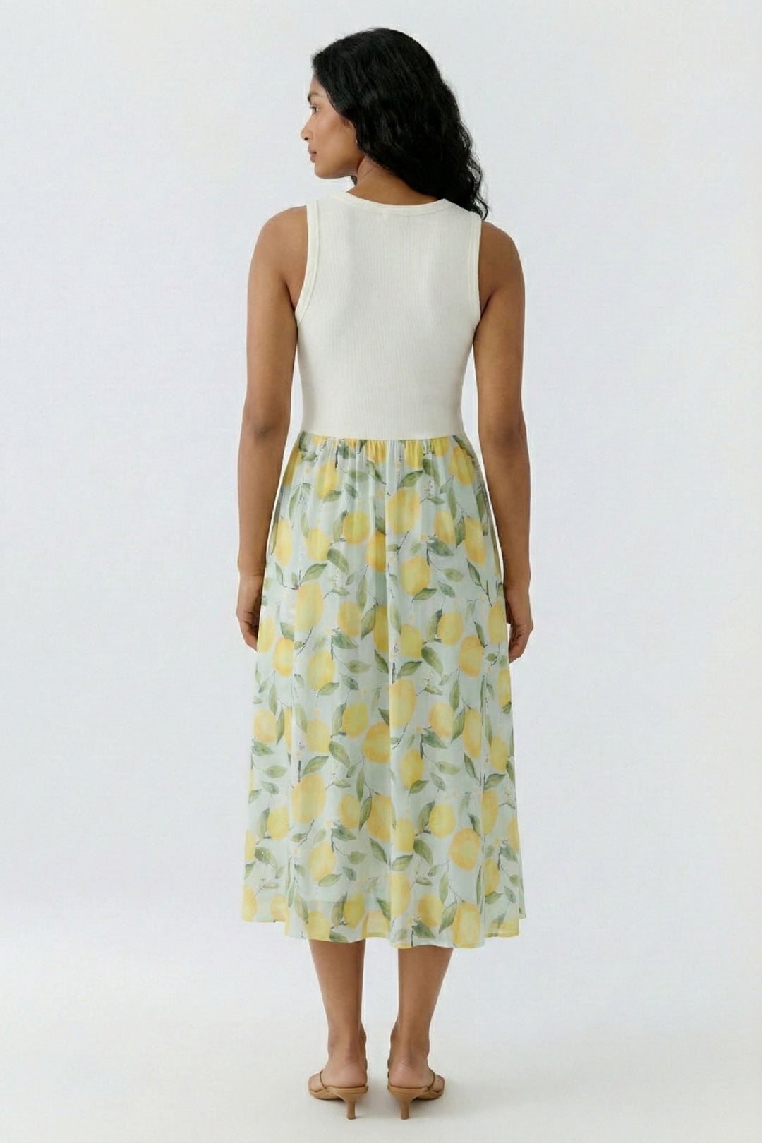 Robe longue sans manches à jupe fluide avec motifs, vue de dos montrant coupe ajustée et tissu léger pour confort quotidien.