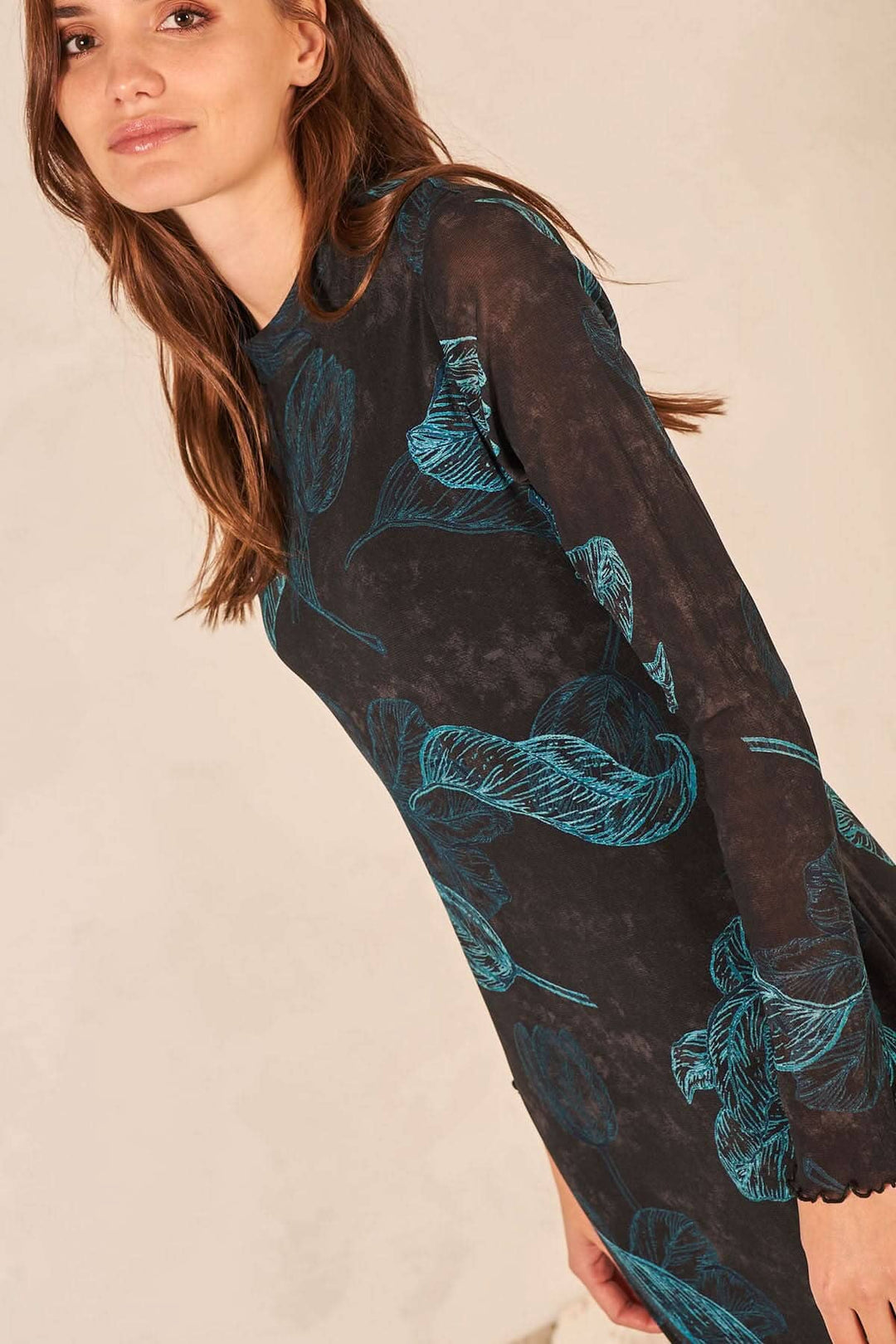 Robe longue à manches transparentes avec imprimé de feuilles sur fond noir, coupe ajustée et léger col monté.