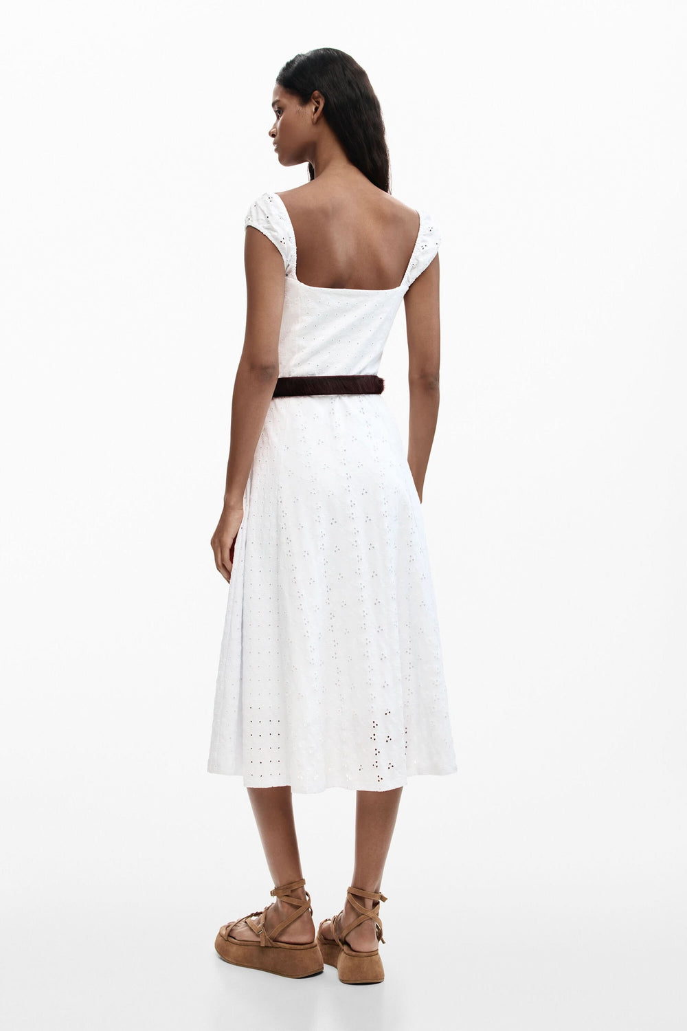 Femme portant une robe midi brodée en broderie anglaise avec une encolure cœur et bretelles larges, vue de dos.