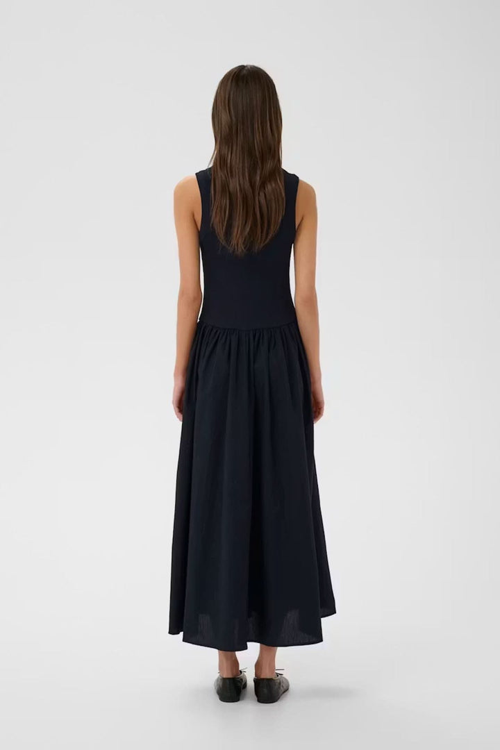 Vue arrière de la robe midi sans manches Dagnama montrant une silhouette féminine avec haut ajusté et jupe ample.