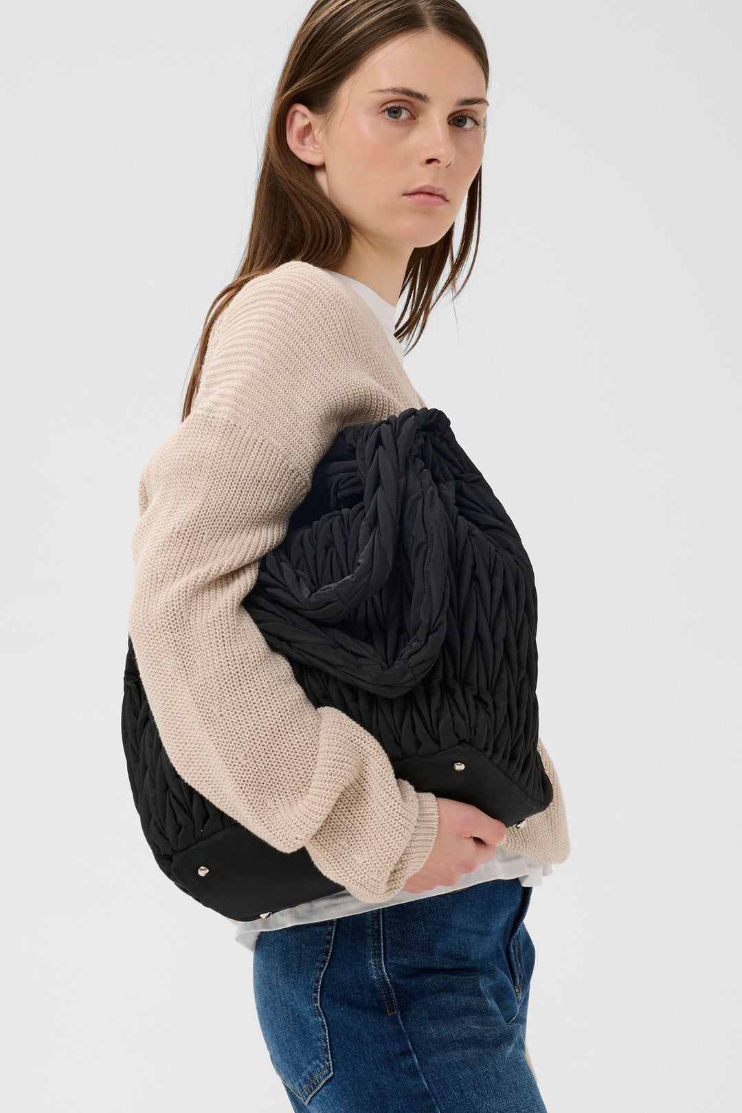 Femme portant un sac fourre-tout matelassé Samy, parfait pour un usage urbain ou professionnel, avec texture distincte.