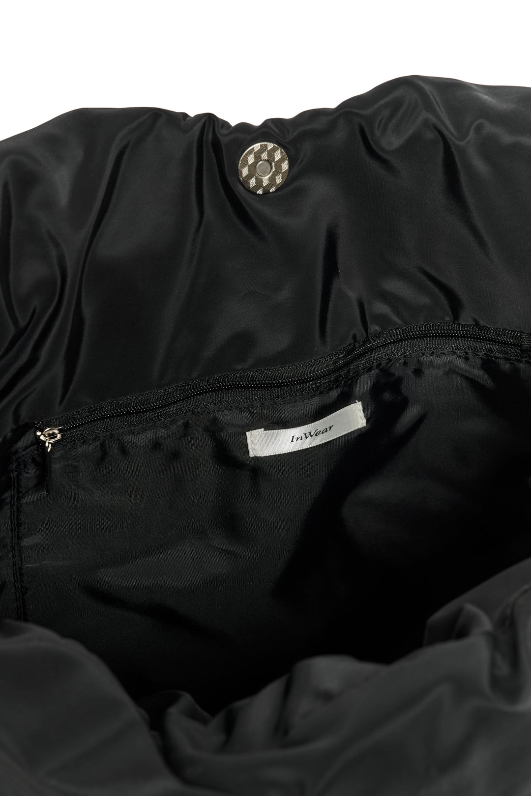 Intérieur du sac fourre-tout matelassé Samy avec doublure noire et poche zippée. Pratique et élégant pour un usage quotidien.