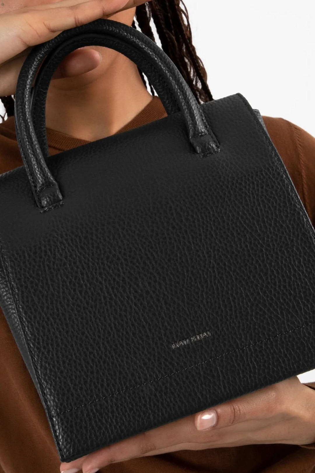 Sac à main noir Adelsm à double poignée, élégant et fonctionnel, avec rabat structuré.