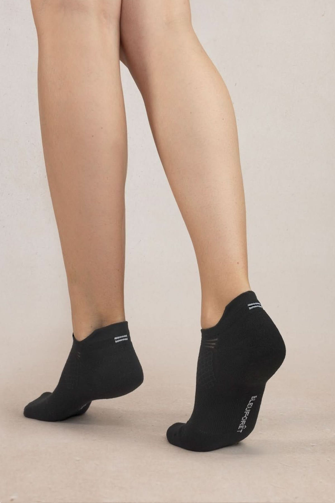 Femme portant des socquettes sport dynamic noires, offrant confort et respirabilité pour les activités sportives.
