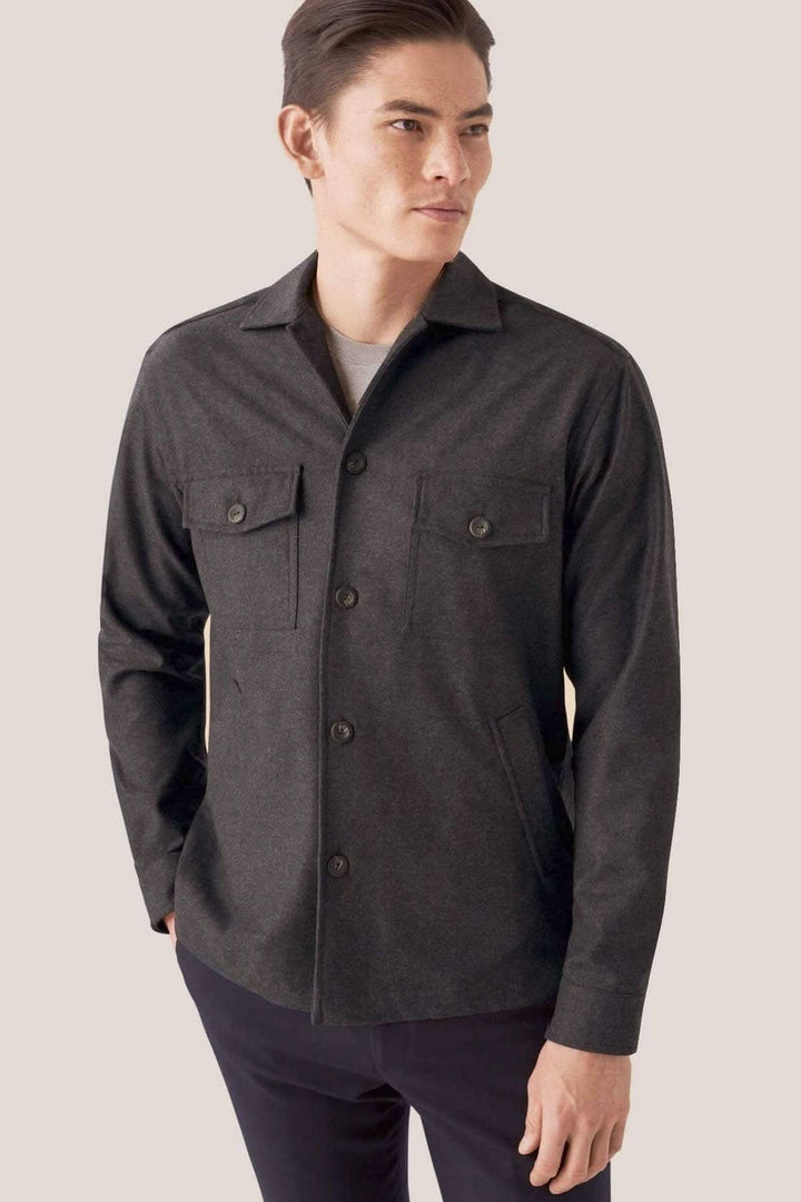 Homme portant une surchemise en flanelle laine et cachemire, couleur sombre, avec poches et boutons effet corne.