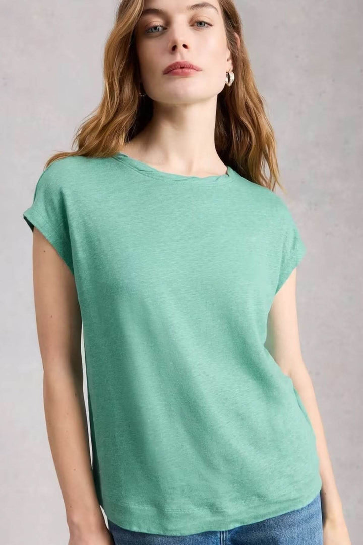 Femme portant un T-Shirt en lin Rowan ample sans manches, couleur vert, avec encolure ronde et coupe fluide, pour un style décontracté.