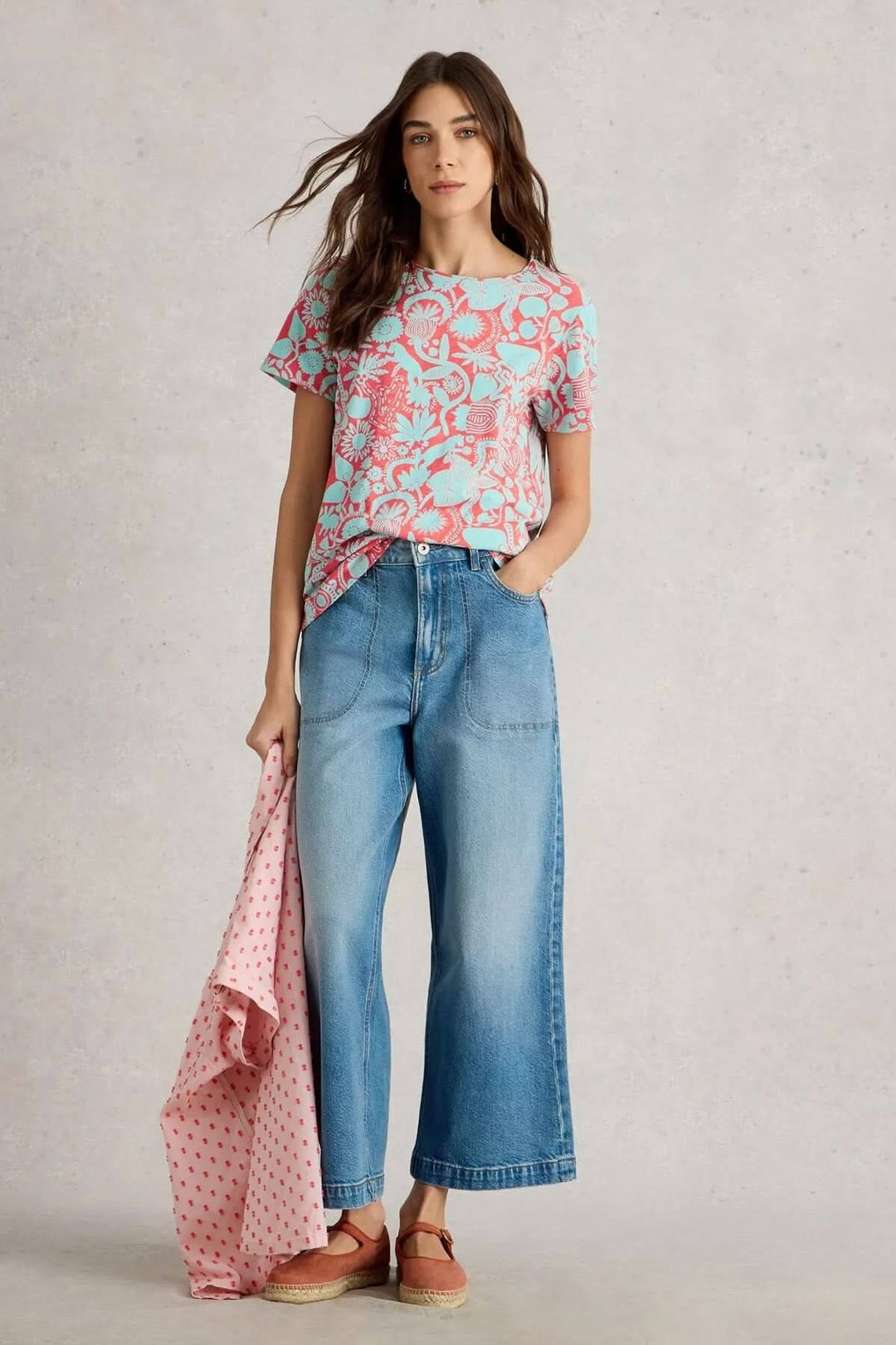 Modèle portant le t-shirt Abbie à imprimé botanique, associé à un pantalon en denim et une écharpe.