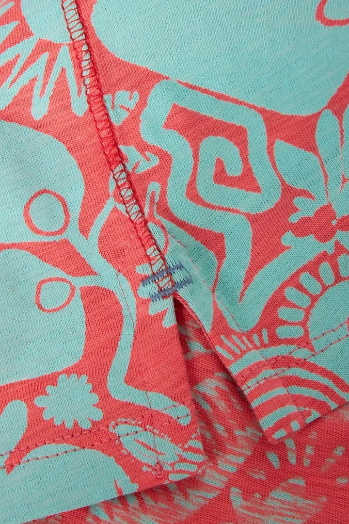 Détails du t-shirt Abbie, avec un imprimé botanique coloré sur fond bleu et corail.